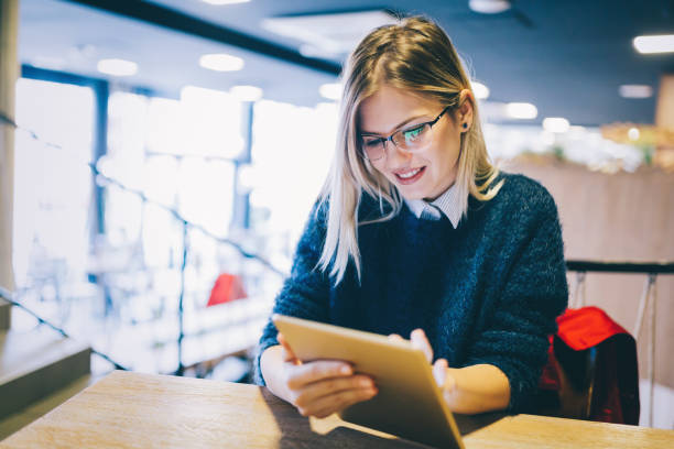 istock Happy young woman using tablet at coffee shop 814362592