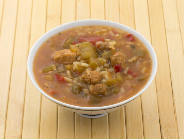 gumbo mit wurst und geflügel fleisch in eine schüssel geben - chicken gumbo stock-fotos und bilder