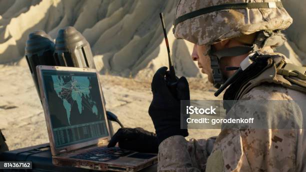 Soldier Is Using Laptop Computer And Radio For Communication During Military Operation In The Desert Stock Photo - Download Image Now