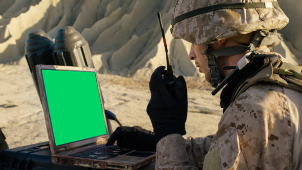 istock Soldier is Using Laptop Computer with Green Screen and Radio for Communication During Military Operation in the Desert. 814367174