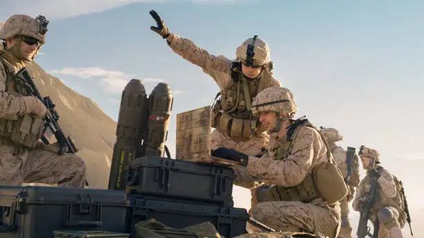 Photo of Soldiers are Using Laptop Computer for Surveillance During Military Operation in the Desert.