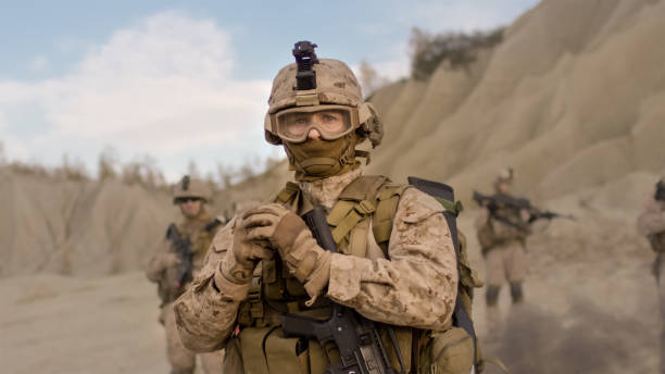 istock Soldier Preparing a Grenade for Throwing during Combat in the Desert. 814367302