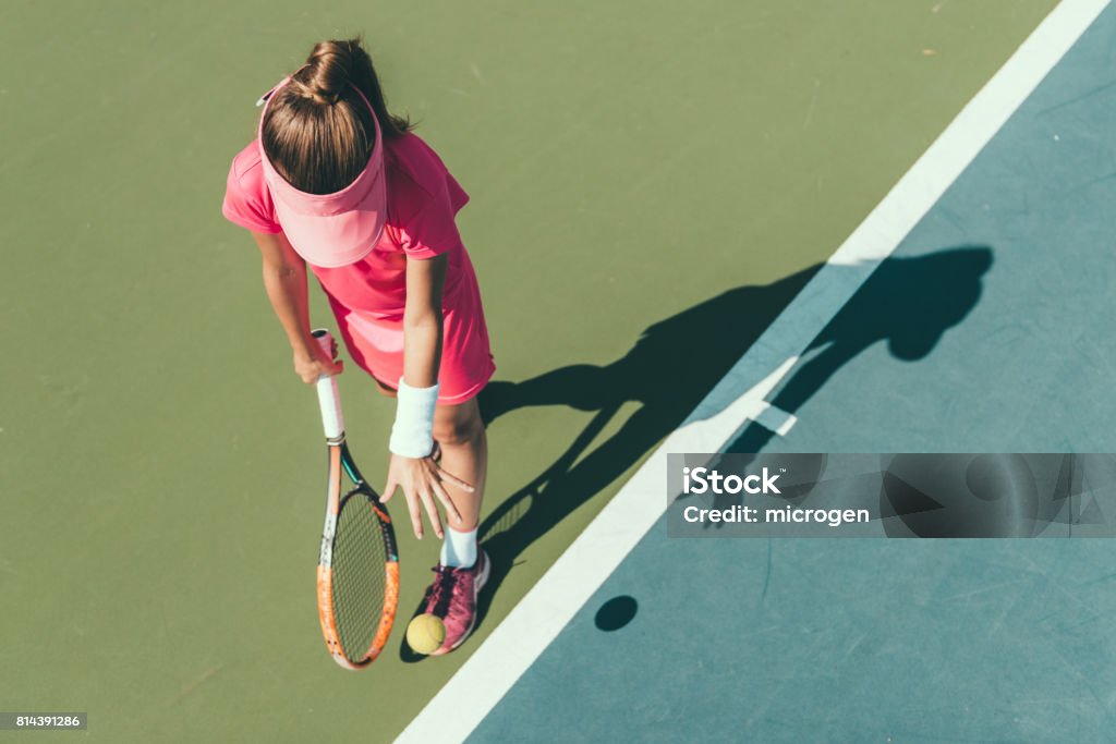 Young girl playing tennis, preparing to serve Tennis Stock Photo