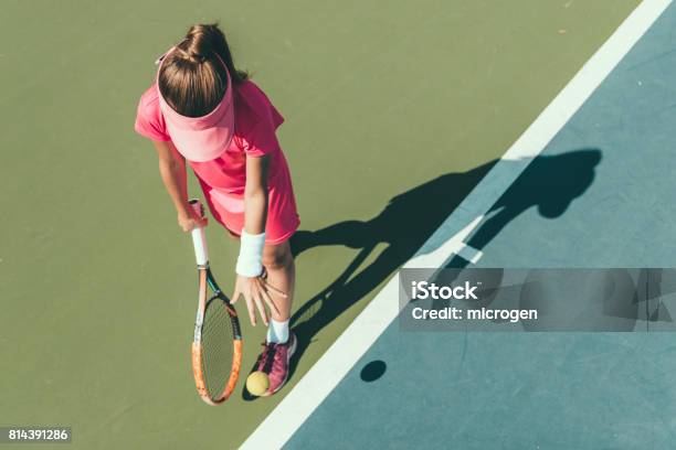 Young Girl Playing Tennis Preparing To Serve Stock Photo - Download Image Now - Tennis, Child, Girls