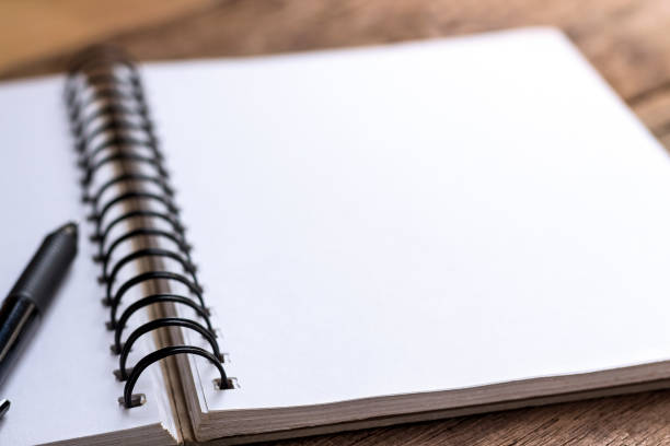 istock pen and notebook on wooden table. 814394056