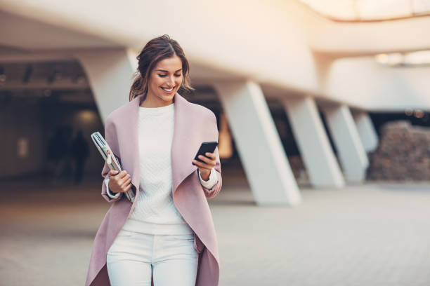 femme à la mode avec téléphone intelligent - stéréotype de la classe supérieure photos et images de collection