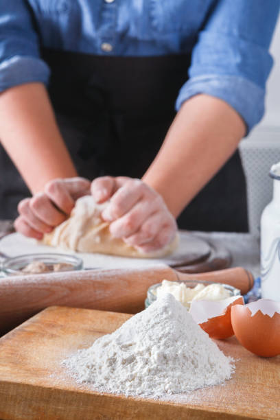 istock Woman baker knead yeast dough with eggs and flour 814408154