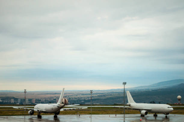 flugzeug auf dem nassen asphalt - airfield mountain snow airport stock-fotos und bilder