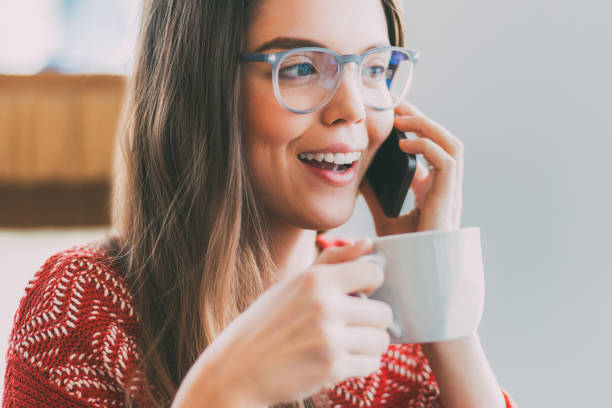 istock Cute Woman Drinking Coffee and Talking on Phone 814423314