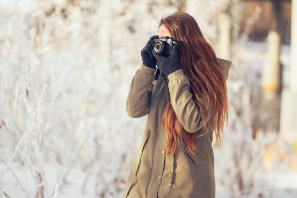 istock Young Woman Taking Photos in Winter Forest 814423426