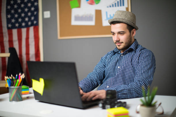 Good-looking Black man looks bored and troubled as he sits at his laptop computer.