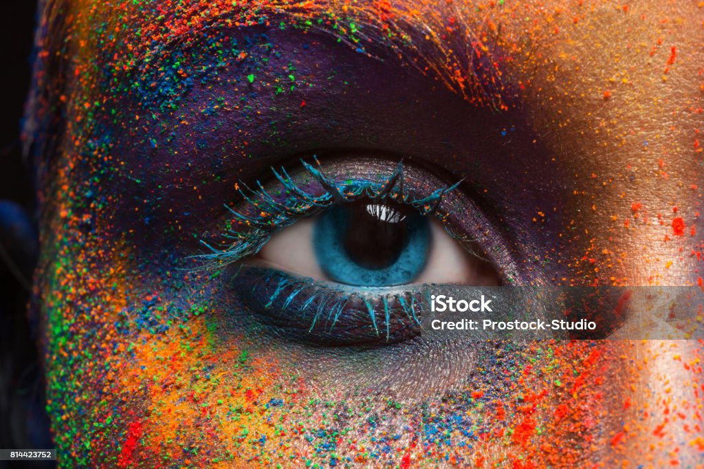 Eye of model with colorful art make-up, close-up Crop of female eye with colorful make up. Beautiful fashion model with creative art makeup. Abstract colourful splash make-up. Holi festival Colors Stock Photo