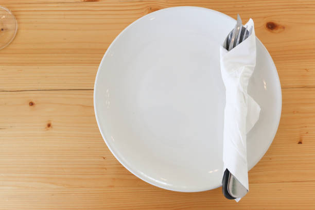 istock spoon and fork are wrapped by white tissue on white dish and wood table 814434816