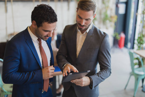 istock Two young businessmen discussing business strategy using digital tablet 814442518