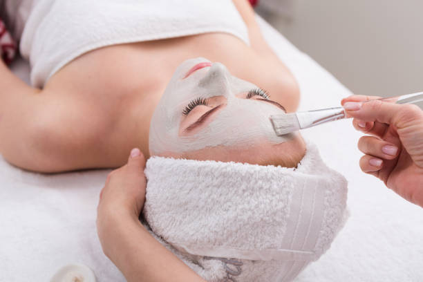 istock Woman gets face mask by beautician at spa 814461340