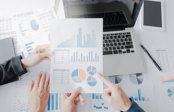 istock Business team hands at working with financial plan and a tablet, laptop on office desk,  Top view shot 814484330