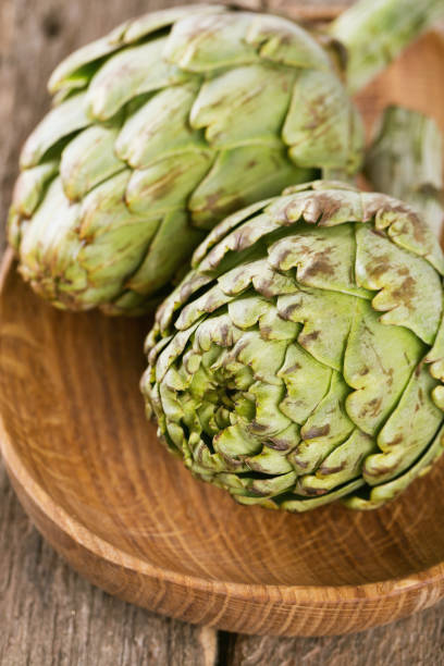istock artichokes on wooden table 814491176