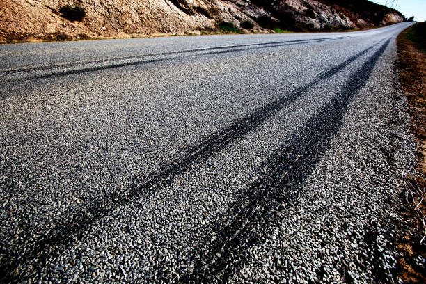 fahrzeug reifen bremse skidmarks auf ländlichen asphaltstraße - tire track track asphalt skidding stock-fotos und bilder