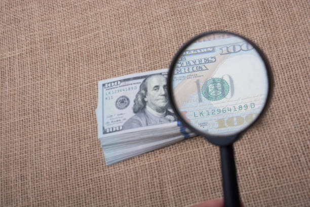istock Magnifying glass over the banknote bundle of US dollar 814520850