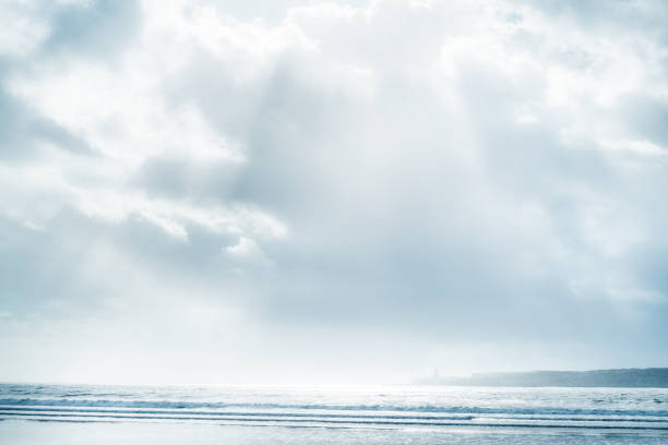 Beach and sea with cloudy sky and sunbeams. High key, soft effect image.