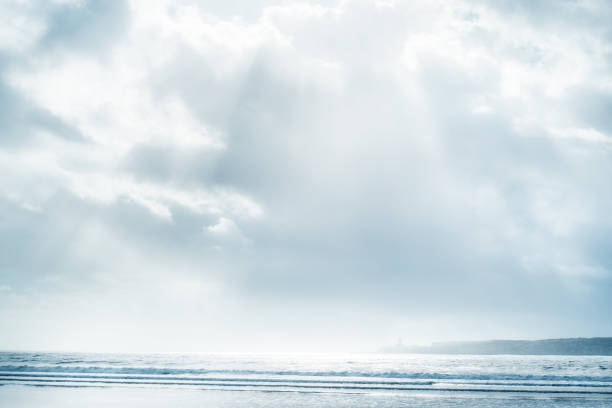 Beach and sea with cloudy sky and sunbeams. stock photo