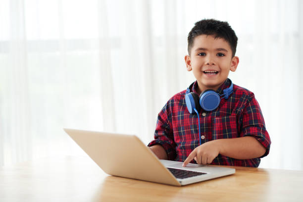 niño con una computadora portátil - filipino ethnicity audio fotografías e imágenes de stock