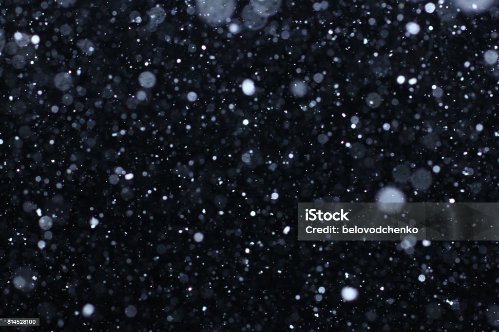 Snowstorm texture. Bokeh lights and Falling snow on a black background Snow Stock Photo