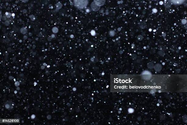 Snowstorm Texture Bokeh Lights And Falling Snow On A Black Background Stock Photo - Download Image Now