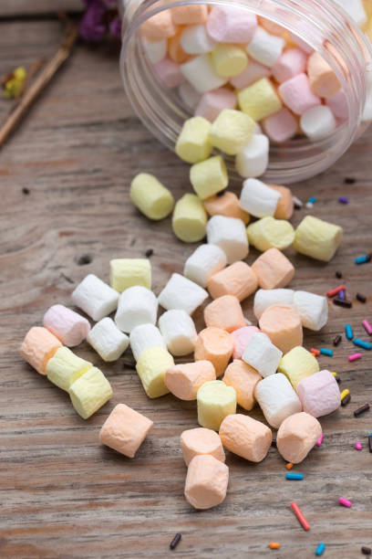 istock Pink and white mini marshmallows in a jar on an old rustic wooden table with space for text. Mini white and pink puffy marshmallows. Marshmallow concept. 814534656