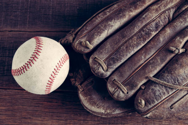 istock old Baseball and glove on wood background with filter effect retro vintage style 814540892