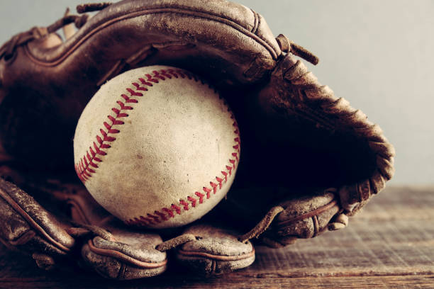 istock old Baseball and glove on wood background with filter effect retro vintage style 814540930