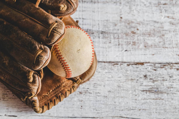 istock old Baseball and glove on wood background with filter effect retro vintage style 814540942
