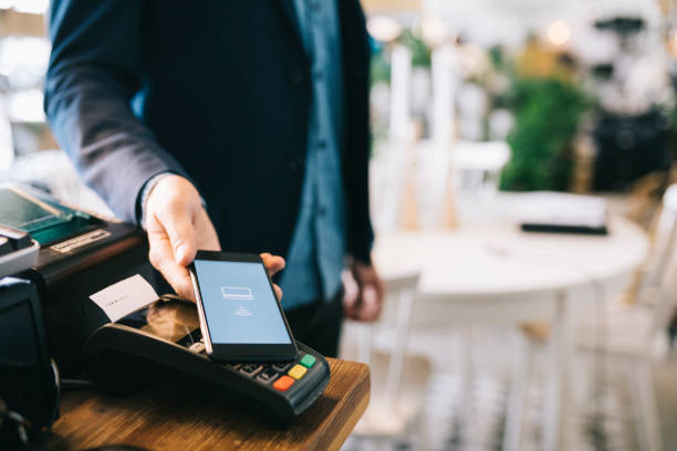 Mobile payment Man paying with smartphone using NFC. digital wallet photos stock pictures, royalty-free photos & images