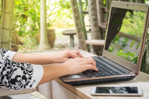 istock Woman use computer. With garden view background. 814552170