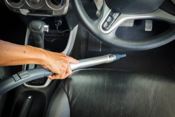 Man holding vacuum handle cleaning inside cabin car. Electronic equipment for dust clean.