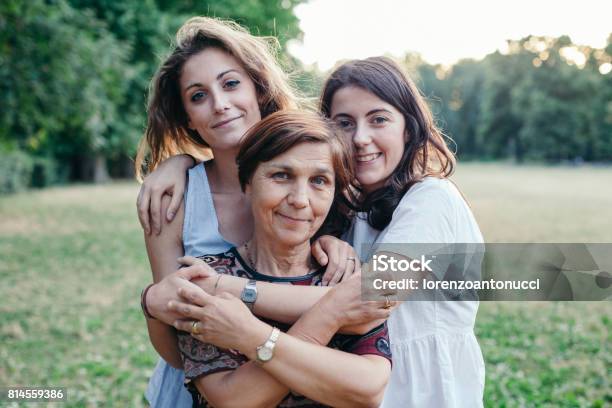 Mutter Und Töchter Umarmung In Einem Park Bei Sonnenuntergang An Einem Sommerabend Stockfoto und mehr Bilder von Mutter