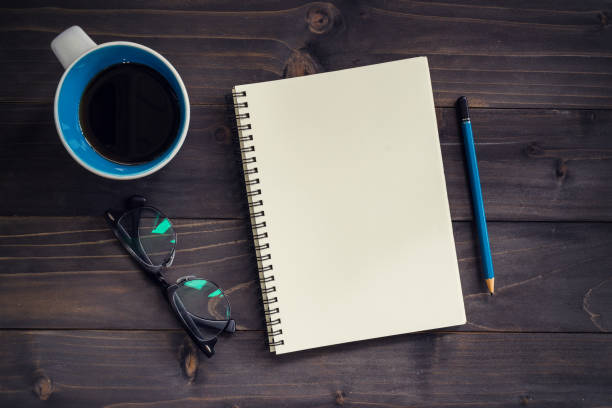 istock Office wood table with blank notepad, pencil, glasses and cup of coffee. 814594078