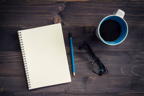 istock Office wood table with blank notepad, pencil, glasses and cup of coffee. 814596162