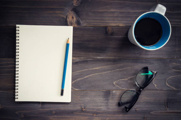 istock Office wood table with blank notepad, pencil, glasses and cup of coffee. 814596204