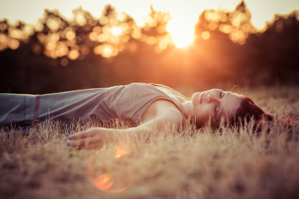 Woman lying in grass and enjoying the sunset
