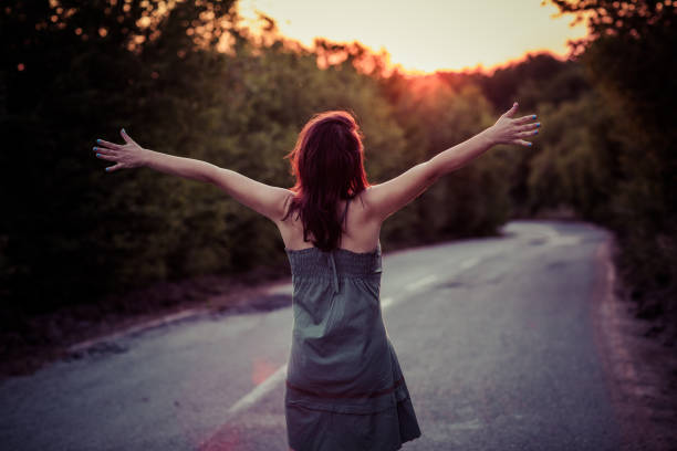 istock Woman hitchhiking on highway at sunset 814599204