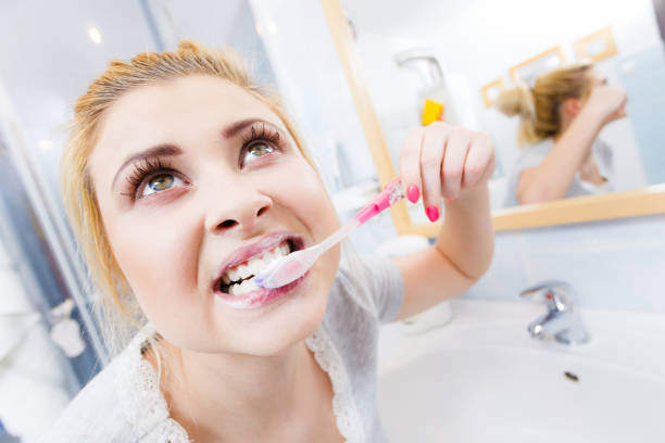 istock Woman brushing cleaning teeth in bathroom 814605258