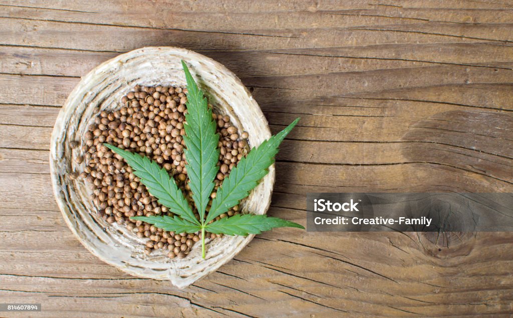 Cannabis seeds in a bowl on a wooden background Cannabis seeds in a bowl on rustic wooden background Cannabis Plant Stock Photo