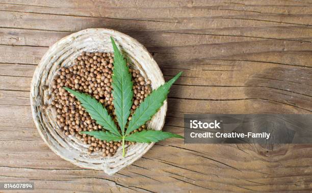 Cannabis Seeds In A Bowl On A Wooden Background Stock Photo - Download Image Now - Cannabis Plant, Seed, Hemp
