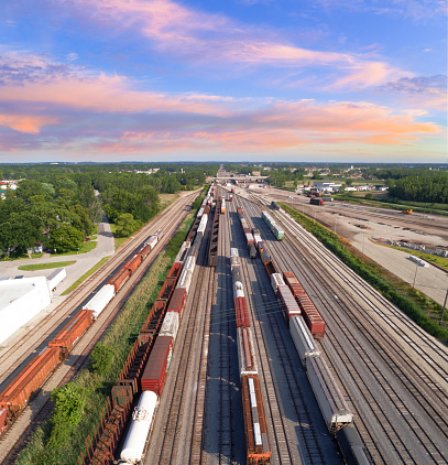 Dynamic aerial view of industrial railroad rail train yard, many trains, tracks.