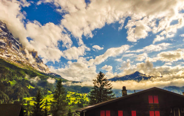 majestic panoramic view of grindelwald landscape and cloudscape with golden light reflected, canton of berne, bernese oberland, switzerland, europe.. starting village for first and jungfraujoch. - interlaken railroad station train rural scene imagens e fotografias de stock