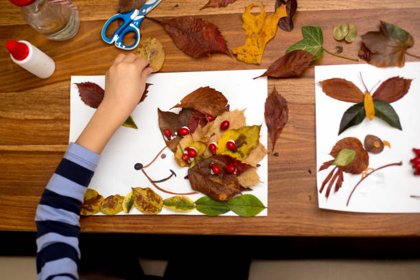 doce criança, rapaz, aplicando folhas usando cola enquanto fazendo artes - arte e artesanato objeto manufaturado - fotografias e filmes do acervo
