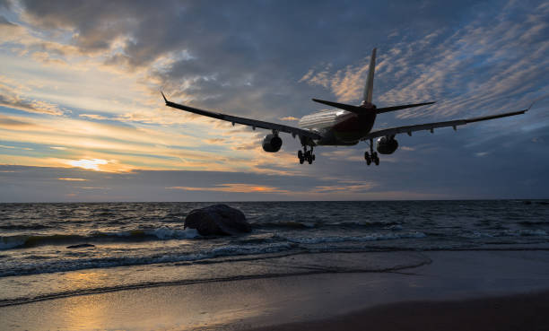 istock Airplane flying over the sea at sunset 814664412
