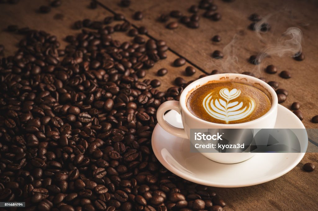 Coffee beans and Hot Cofee cup with latte art on wooden background. side view with copy space for your text Coffee Crop Stock Photo