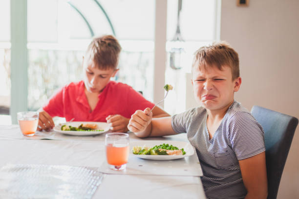 Boys Eating Dinner Boys eating dinner and making faces grotesque stock pictures, royalty-free photos & images
